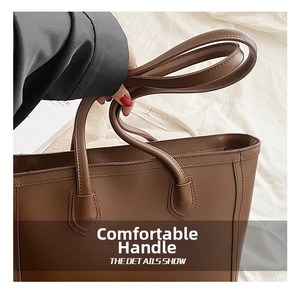 Close-up of the comfortable handle with reinforced stitching on the brown tote bag
