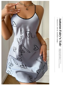 Détail d'une nuisette en satin argenté avec imprimés love noirs et motifs de cœurs