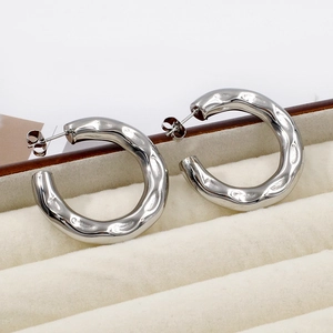 Detail of silver hammered stainless steel hoop earrings in a velvet display box
