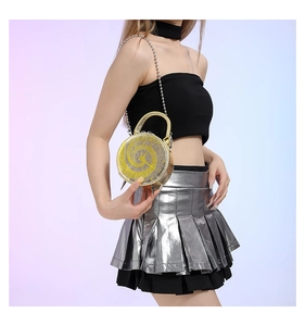 Close-up of yellow round clock-shaped crossbody bag featuring silver studs and chain strap