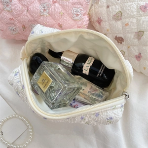 Innenansicht einer gesteppten Kosmetiktasche mit Blumenmuster und großem Stauraum für Make-up