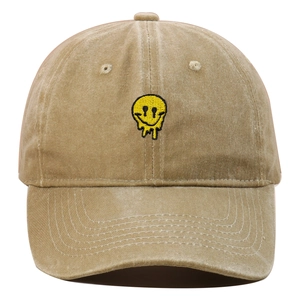 Detailed embroidery of a melting yellow smiley face on a washed khaki baseball cap