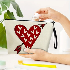 Canvas makeup bag with heart print and zipper, being used for portable storage