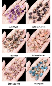 Detail of natural raw stone pendants with gold electroplated caps in six crystal types