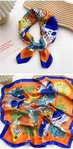 Detail of silk square scarf featuring bold orange and royal blue abstract floral patterns
