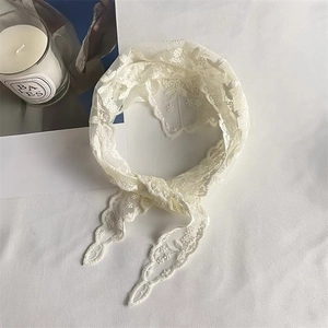 Close-up of cream white floral lace hair scarf with vintage scalloped edges