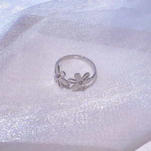 Gros plan détaillé d'une bague réglable en argent avec deux motifs de tournesol évidés