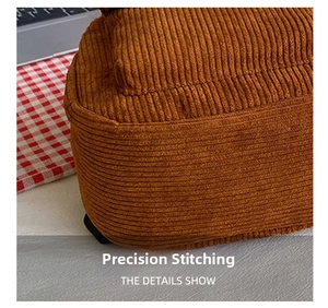Detail of brown corduroy fabric and precision stitching on the mini backpack strap