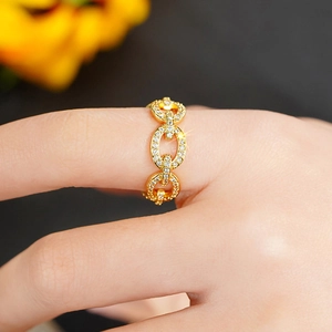 Close-up of golden interlocking chain ring with micro-pave white zircon crystals