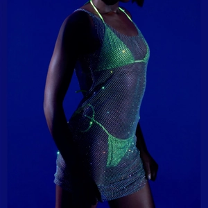 Détail d'une robe en maille strass argentée sur un ensemble bikini vert néon sur mannequin