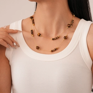 Double-layered tiger eye bead necklace with gold metal accents on female model