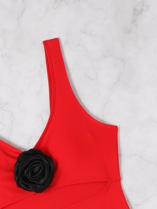 Detailed view of red swimsuit with a black handmade 3D rose on the shoulder strap