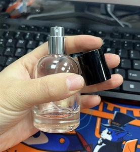 Dettaglio flacone di profumo in vetro da 30ml con spray argento e cappuccio nero