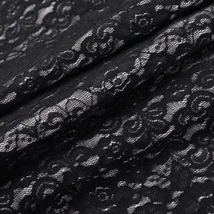 Gros plan du tissu en dentelle noire avec motifs floraux et texture mesh sur la robe