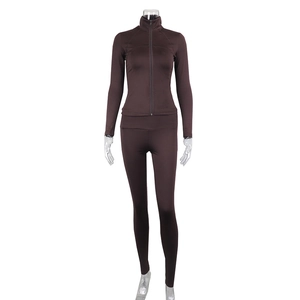 Detail of slim fit dark brown sports set featuring stand collar zipper jacket and leggings