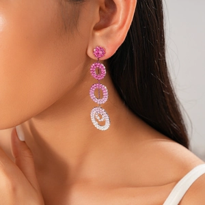 Detailed view of long interlocking hoop earrings with pink gradient stones on a model
