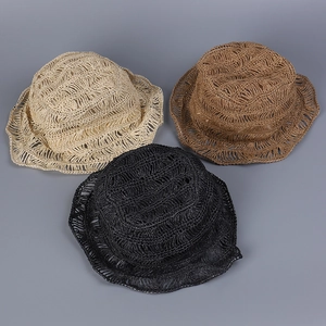 Detailed view of handmade hollow straw fisherman hats in three neutral colors