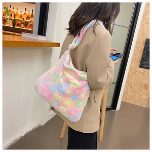 Plush floral tote bag shown in a modern cafe setting with soft colorful flower patterns
