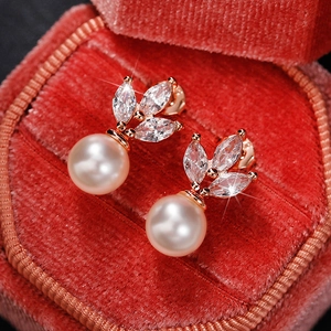 Close-up of pearl drop earrings with leaf-shaped marquise zircon in a red velvet box