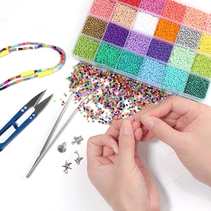 Macro view of DIY bead kit including colorful glass beads, metal charms, and craft tools