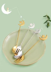 Detail of star and moon shaped handle tops on gold and silver stainless steel cutlery