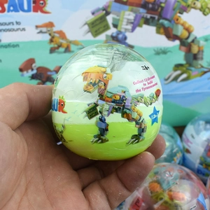 Handheld view of a 12-in-1 dinosaur building block egg toy with yellow bricks inside