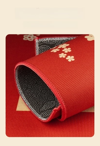 Close-up of red non-slip door mat with floral pattern and reinforced stitched edges