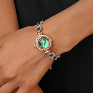 Detail of rose gold watch with green floral dial and zircon stones on female wrist