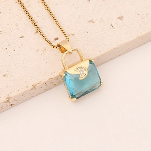Macro shot of handbag pendant with aqua blue zircon and gold moon detail