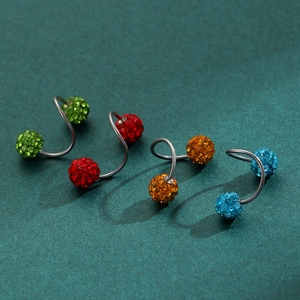 Detail of colorful disco ball spiral earrings in green, red, amber, and blue crystals