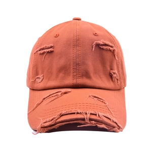 Détail de la casquette orange avec bord effiloché et style rétro aux finitions déchirées