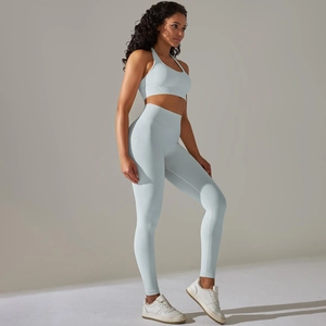 Detail of seamless ribbed high-waist yoga pants and sports bra set in light blue