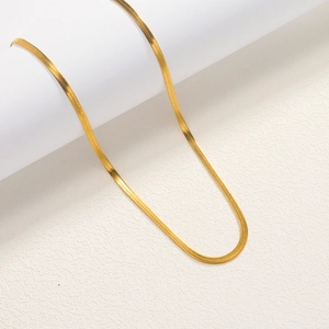 Detail of a polished gold-plated stainless steel snake chain with a smooth mirror finish