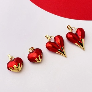 Detail of red and gold melting heart pendants in various sizes with enamel finish