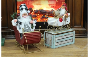 Close-up of Santa Claus in black and white plaid suit sitting on wooden sled decorations