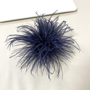 Detailed view of dark blue ostrich feather brooch for elegant party dress accessories