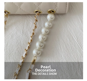 Detailed close-up of quilted white leather bag with gold chain and large pearl pendant