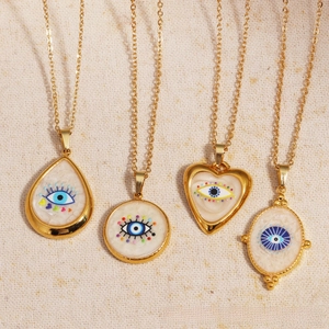 Close-up of titanium steel necklace with evil eye pendants in heart and round shapes