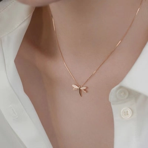 Elegante collana con ciondolo a libellula in oro rosa e pietre brillanti su una modella