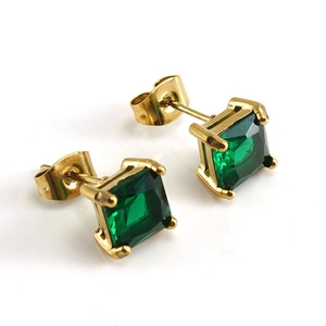 Macro view of gold square stud earrings with green zircon and four-prong setting