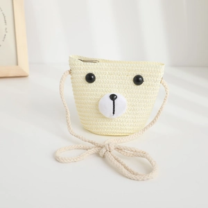 Dettaglio di una borsa a tracolla in paglia per bambini a forma di orsetto beige