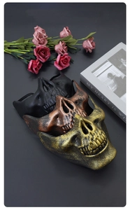 Detailed view of three vintage-style skull half masks in gold, bronze, and black finishes