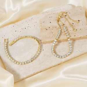 Luxury gold-plated two-piece zircon bracelet set on elegant silk and stone background