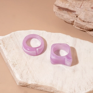 Detail of two-piece purple marble acrylic rings showing geometric square and round shapes