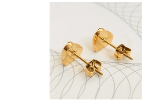 Close-up of polished gold heart stud earrings with secure butterfly backings