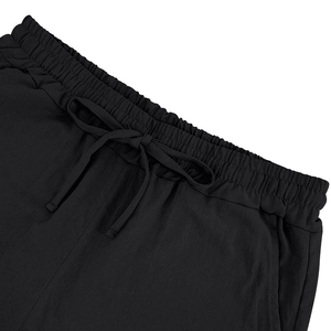 Macro shot of black linen shorts featuring an elastic drawstring waistband and side pockets