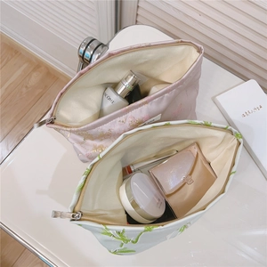 Vue macro du tissu brodé jacquard floral et de la fermeture éclair du sac à cosmétiques