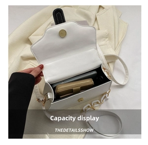 Internal capacity of the white flap bag showing space for phone and wallet