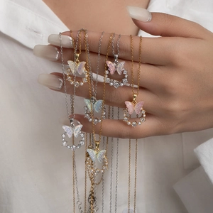 Detail of elegant butterfly necklaces with colorful stones and pearls on white shirt