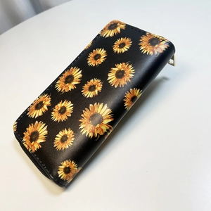 Detail of yellow sunflower print on black PU leather long wallet with gold zipper